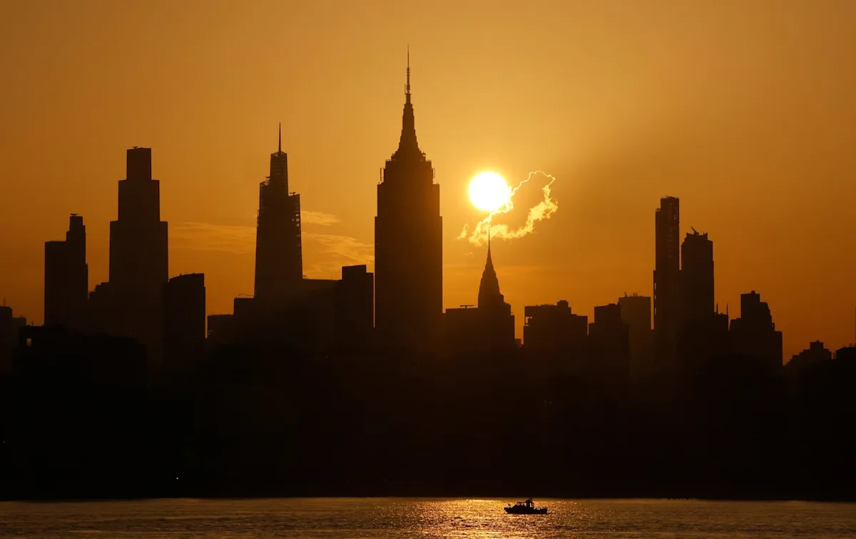 Gary Hershorn/ABC News - FOTO: O sol nasce atrás do horizonte do centro de Manhattan, do Chrysler Building e do Empire State Building em um dia com alerta de calor extremo na cidade de Nova York, 2 de julho de 2026.
