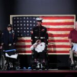 U.S. Navy veteran Harry Rose (L), U.S. Marine Corps veteran Donald Graves (C), and retired U.S. Army Captain Ken Schubring and his son (R) are recognized on stage by U.S. President Donald Trump during