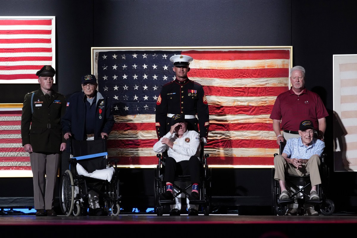 U.S. Navy veteran Harry Rose (L), U.S. Marine Corps veteran Donald Graves (C), and retired U.S. Army Captain Ken Schubring and his son (R) are recognized on stage by U.S. President Donald Trump during