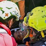Uma equipe de resgate internacional auxilia Hernan Gil, sobrevivente dos dois terremotos da Venezuela, em Catia La Mar, estado de La Guaira, Venezuela, em 2 de julho de 2026, oito dias após o terremoto. Hernan Gil, um segurança de 43 anos, foi enterrado no estande do prédio de sete andares onde trabalhava em Catia La Mar, zona costeira do estado de La Guaira devastada pelo desastre.