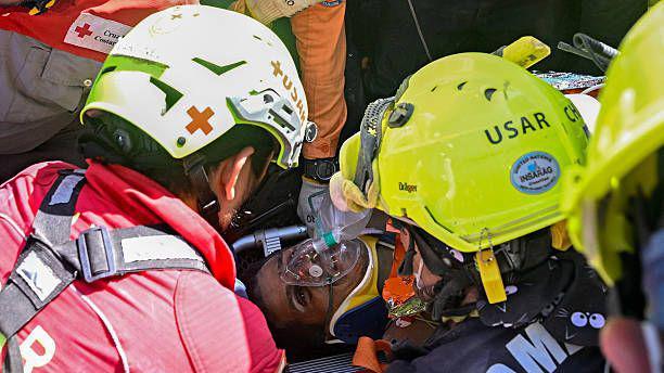 Uma equipe de resgate internacional auxilia Hernan Gil, sobrevivente dos dois terremotos da Venezuela, em Catia La Mar, estado de La Guaira, Venezuela, em 2 de julho de 2026, oito dias após o terremoto. Hernan Gil, um segurança de 43 anos, foi enterrado no estande do prédio de sete andares onde trabalhava em Catia La Mar, zona costeira do estado de La Guaira devastada pelo desastre.