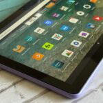Tablet Amazon Fire no centro de um fundo rosa e amarelo do velocímetro
