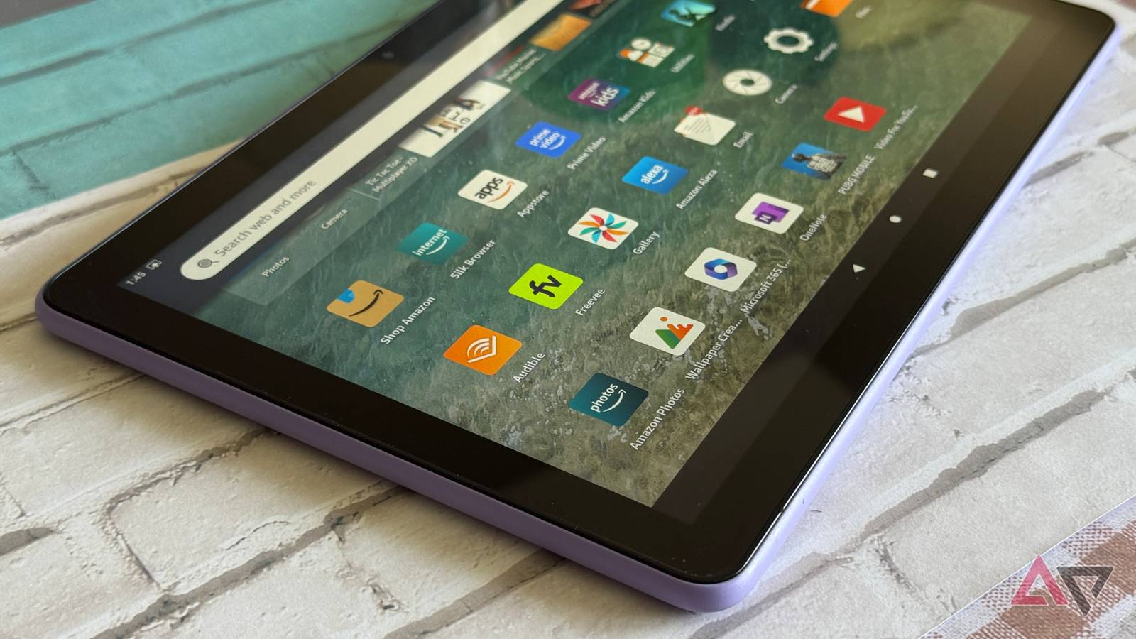 Tablet Amazon Fire no centro de um fundo rosa e amarelo do velocímetro