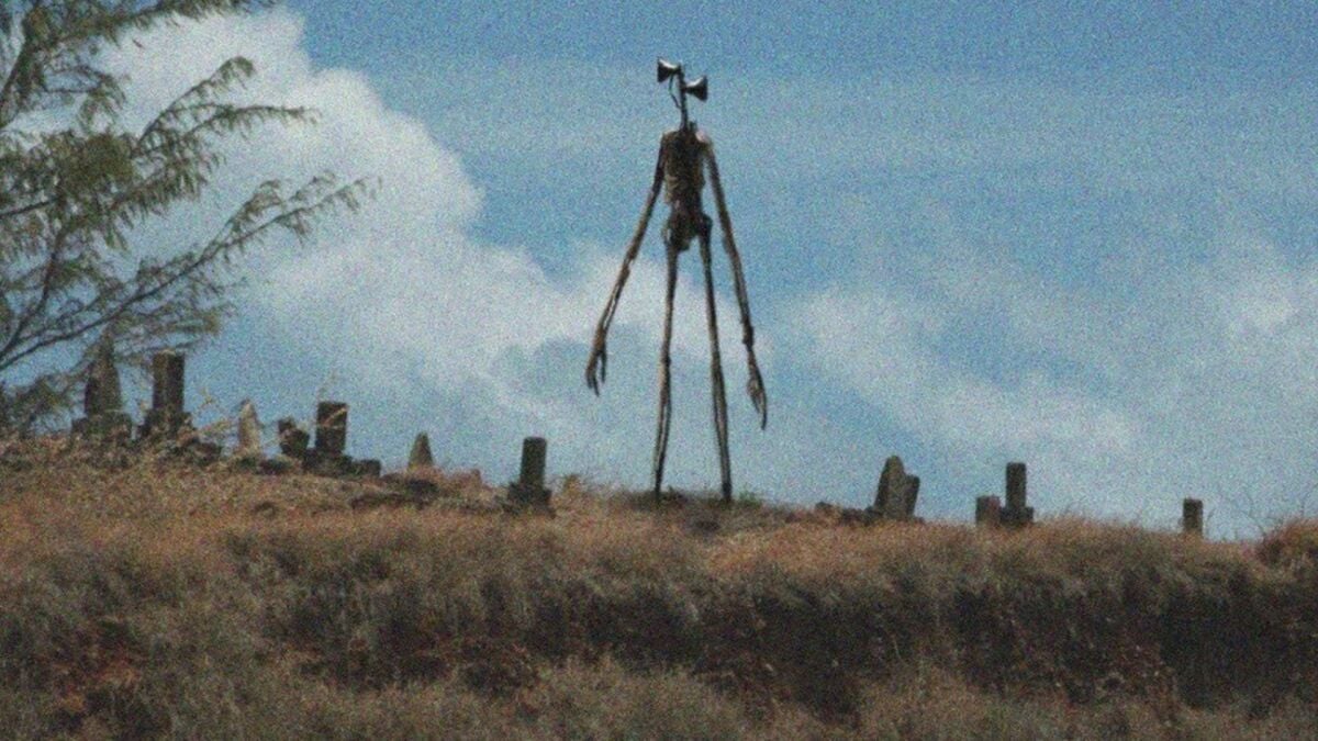 Um monstro alto é visível no horizonte ao anoitecer.